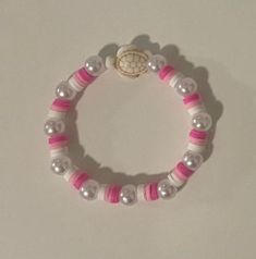 a pink and white beaded bracelet with a small turtle charm on it's end