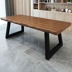 a large wooden table sitting on top of a stone floor next to a book shelf