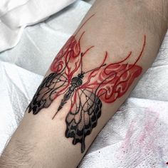 a man with a tattoo on his arm has a red and black butterfly design on it