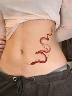 a woman's stomach with a snake tattoo on the side and her lower body