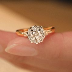 a close up of a person's hand holding an engagement ring