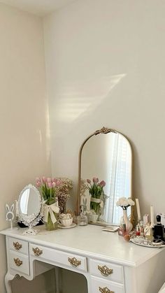 a white desk topped with a mirror and lots of drawers