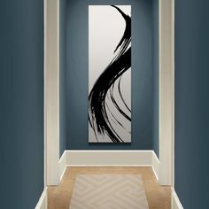 an abstract painting hangs in the corner of a room with green walls and white trim