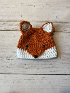 a crocheted hat with an orange and white fox head