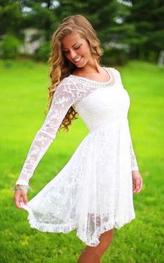 a beautiful young woman in a white dress posing for the camera