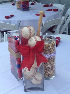 a baseball themed table centerpiece in a clear vase with a red bow on it