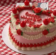 a heart shaped birthday cake with cherries on top