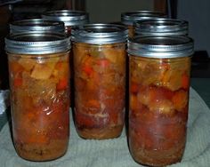 four jars filled with food sitting on top of a table