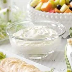 some food is sitting on a table next to a bowl of fruit and dips