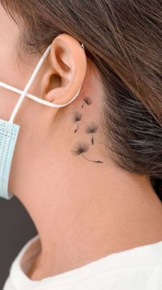 a woman with a dandelion tattoo behind her ear