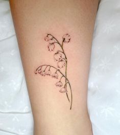 a small flower tattoo on the right side of the leg, with pink flowers growing out of it