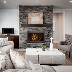 a living room filled with furniture and a fire place in the middle of the room