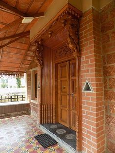 an ornate wooden door on the side of a brick building with tiled floors and walls