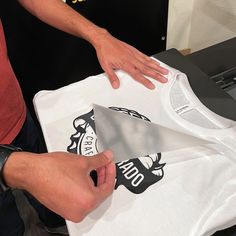 a man is cutting out a t - shirt with a large knife on top of it