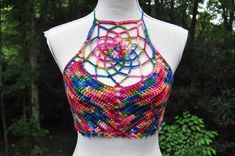 a white mannequin wearing a multicolored halter top with an intricate design