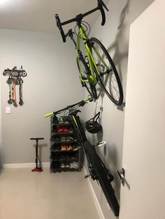 a bike hanging on the wall next to a pair of skis and snowboards