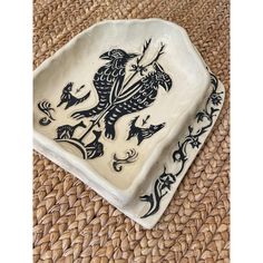 a black and white dish with an animal design on it