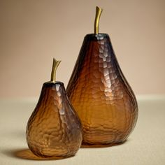 two brown glass pears sitting next to each other