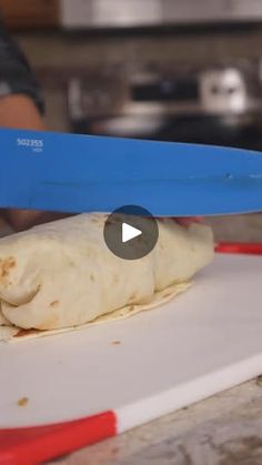 a person cutting up food with a pair of scissors on top of the tortilla