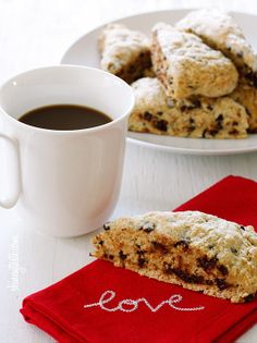 cookies and coffee on a table with love written on the napkin next to it,