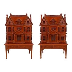 two wooden dolls houses sitting next to each other