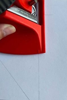 someone is using a pair of scissors to cut out the bottom part of a piece of paper