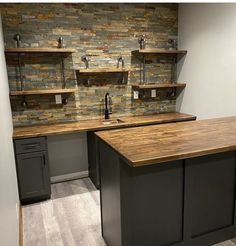 a kitchen with an island in the middle and shelving on the wall behind it