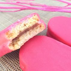 two pink heart shaped cookies sitting on top of a table