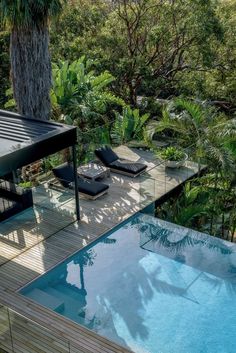 an outdoor swimming pool surrounded by trees and plants