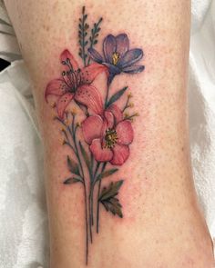 a close up of a person's foot with tattoos on it and flowers in the middle