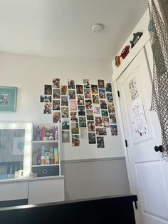 a bedroom with pictures on the wall and a dresser in front of it's door