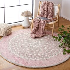 a living room area with a chair, rug and potted plant