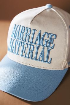 a white and blue hat with the words marriage material on it sitting on a table