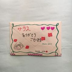 an envelope with japanese writing on it and hearts drawn on the front is decorated with pink flowers