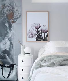 a white bed sitting in a bedroom next to a painting