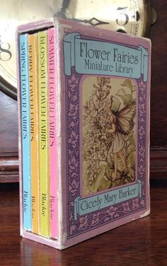 the flower fairies miniature library by cicelly mary baker is displayed in front of a clock