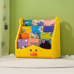 a yellow toy book holder sitting on top of a white rug next to a green wall