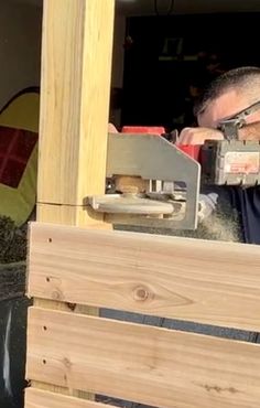 a man using a machine to cut wood