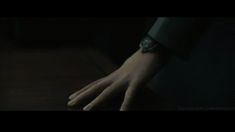 a person's hand with a watch on their wrist in the dark, blurred image