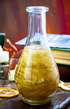 a glass bottle filled with liquid sitting on top of a table next to other items