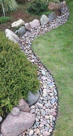 a garden with rocks and grass in the center, along with plants on either side