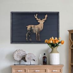 a wooden dresser topped with a vase filled with flowers next to a painting on the wall