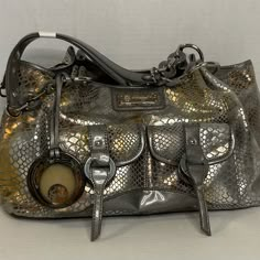 Add A Touch Of Glam Rock To Your Party Outfit With This Vintage Lifestyle By Sharif Handbag. The Silver And Gold Snakeskin Material Gives The Satchel Style A Unique Edge, While The Large Size Provides Ample Space For All Of Your Essentials. The Original 1827 Design Is A Rare Find, Perfect For Vintage Collectors. This Beautiful Bag Is In New Condition. Measurements Are Approximate With Bag Laying Flat. Height Is 10 Inches Width Is 14 Inches Depth Is 5 Inches Handle Drop Is 8 Inches. *****Thanks F Thrift Style, Snake Skin Handbag, Metallic Handbags, Vintage Lifestyle, Cowgirl Aesthetic, Lucky Ladies, Side Bags, Glam Rock