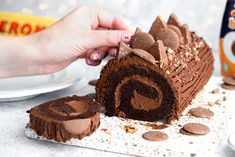 someone is decorating a chocolate roll cake