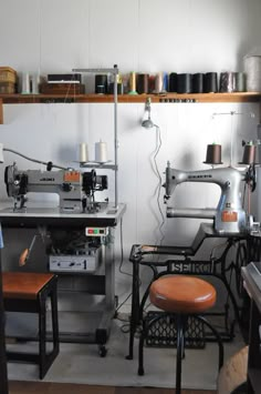 two sewing machines sitting next to each other on top of a wooden shelf in a room