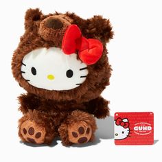 a hello kitty stuffed animal with a red bow on it's head next to a card