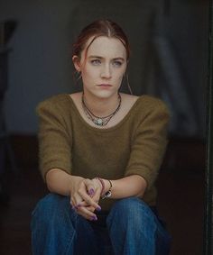 a woman sitting on the ground with her hands crossed