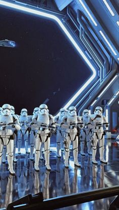 a group of star wars action figures lined up in front of a stage with lights