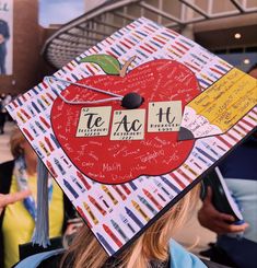 a child wearing a graduation cap with the words te ac'it on it and an apple