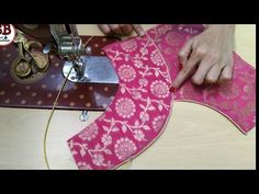 someone is using a sewing machine to sew something on a piece of pink fabric